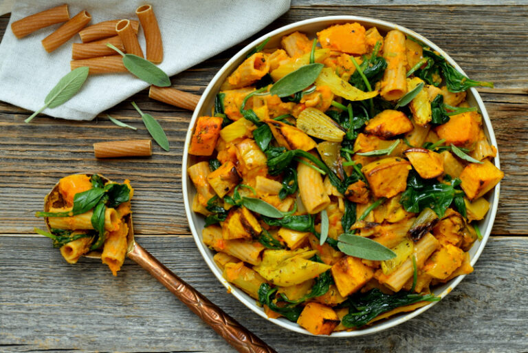 Bovenaanzicht: rechts een wit bord met tortiglioni met butternutsaus link een lepel